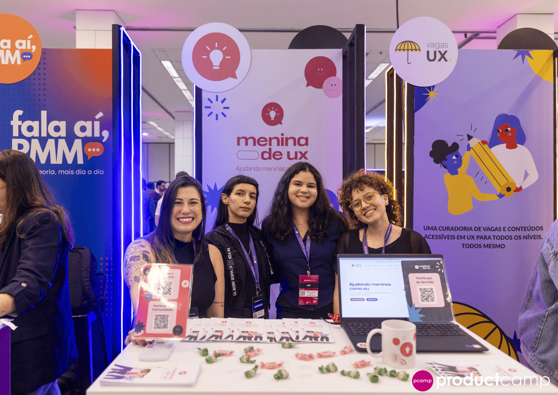 Equipe Menina de UX em evento com stand e alunas